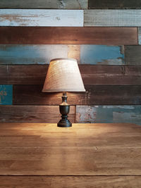 Full frame shot of lamp on table against wall