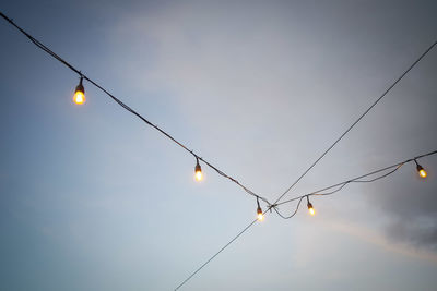 Low angle view of illuminated street light against sky