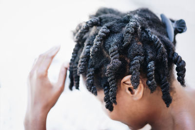 High angle close-up of boy dreadlocks against white background