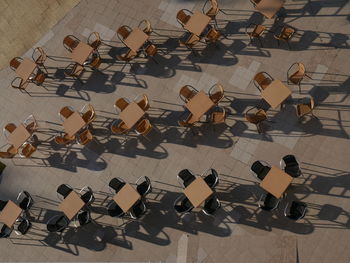 High angle view of chairs and tables arranged at sidewalk cafe