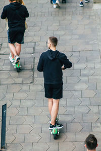 Rear view of men walking on footpath