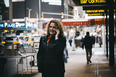 Woman looking at city at night