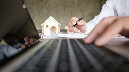 Cropped image of businessman using laptop at desk in office