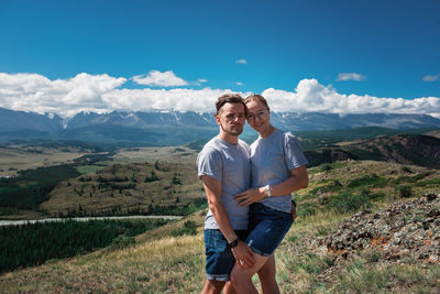 Young man standing on mountain against sky