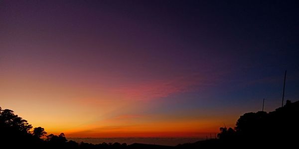 Low angle view of silhouette trees against romantic sky