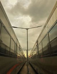 Trains moving against cloudy sky