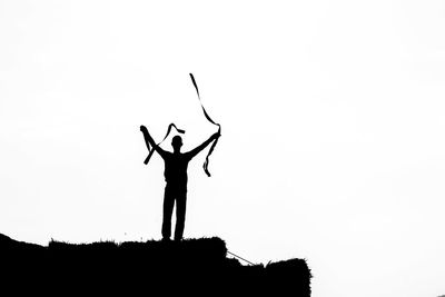 Low angle view of silhouette man standing against clear sky