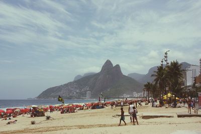 People at beach against sky