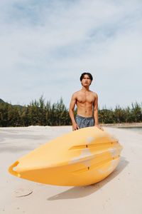 Portrait of shirtless man swimming in sea against sky