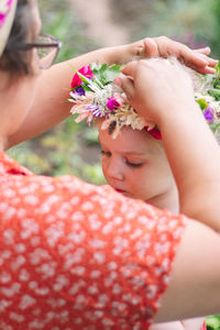 Midsection of woman holding pink flower