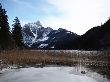 Scenic view of snowcapped mountains by lake against sky