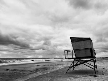 Lifeguard hut on beach against sky