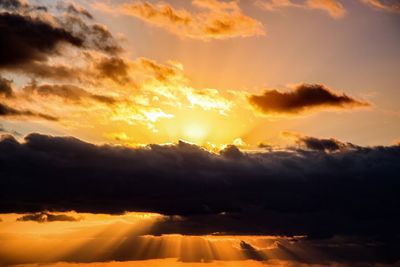 Scenic view of mountains against cloudy sky at sunset