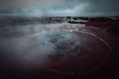 Scenic view of hot spring against sky