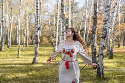  beautiful woman in national ukrainian national traditional costume clothes dancing in forest