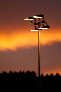 Close-up of silhouette street light against sky at sunset