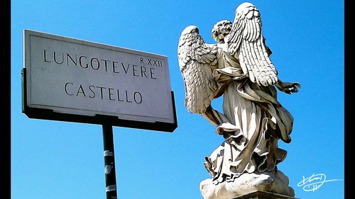 Low angle view of statue against blue sky