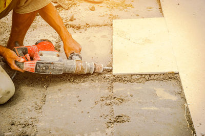 Worker drilling tile