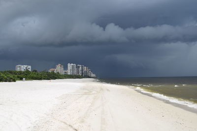 Scenic view of beach and buildings against sky