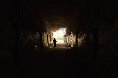 Full length of woman walking in tunnel