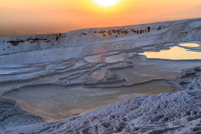 Scenic view of pools against sky during sunset