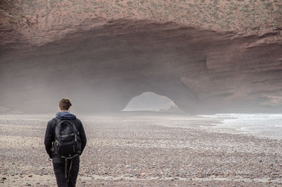 Rear view of man walking against mountain