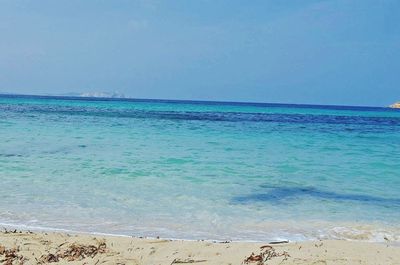 Scenic view of beach against blue sky