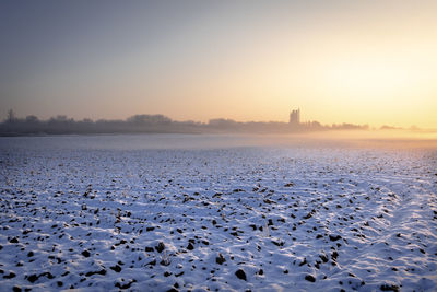 Scenic view of frozen lake against sky during sunset