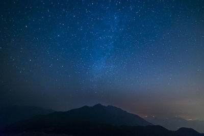 Scenic view of mountains against star field at night