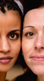 Portrait of crop multiethnic stylish women with earring looking at camera