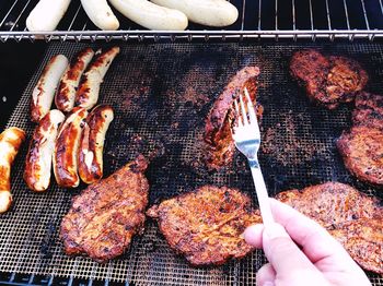 High angle view of person preparing food on barbecue grill