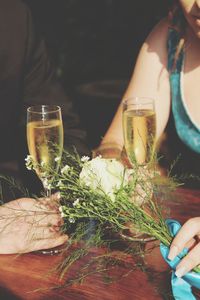 Midsection of woman having champagne at table
