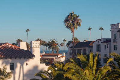 Houses by swimming pool against clear sky