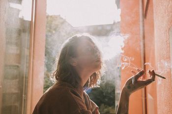 CLOSE-UP OF WOMAN STANDING BY WINDOW