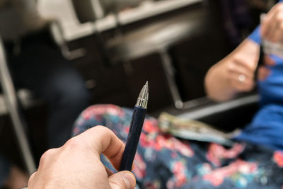 Cropped hand of man holding pen