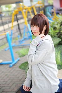 Portrait of young woman sitting in park