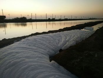 Scenic view of river against sky at sunset