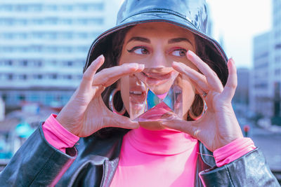 Young woman holding crystal in city