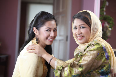 Side view portrait of mother and daughter smiling at home