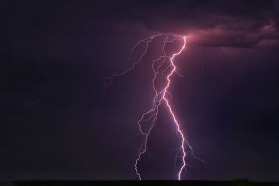 Low angle view of lightning against sky at night