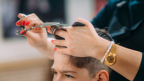 Hairdresser cutting boy's hair in a hair salon