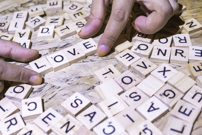 Cropped hands of person playing with wooden blocks on table