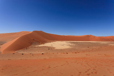 Scenic view of desert against clear blue sky