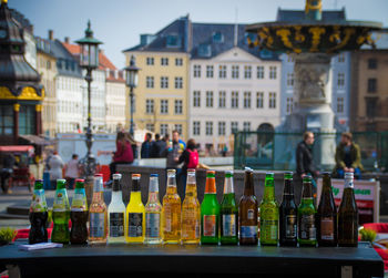 Bottles arranged on table against buildings in city