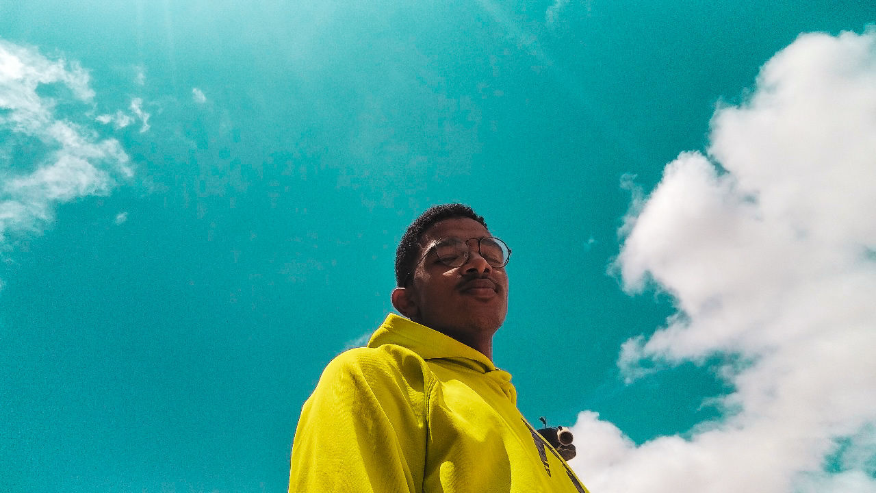 one person, lifestyles, real people, nature, leisure activity, day, mature adult, men, yellow, adult, portrait, sky, waist up, mature men, clothing, blue, cloud - sky, males, looking, outdoors