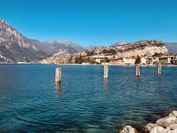 Scenic view of lake and mountains against clear blue sky