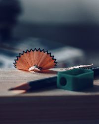 Close-up of pencil with shavings and sharpener on table