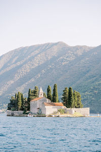Scenic view of sea and mountains against clear sky