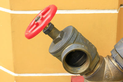 Close-up of machine valve against wall