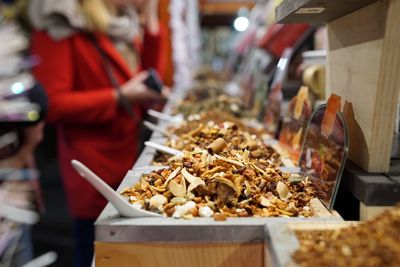 Midsection of woman with food for sale in store